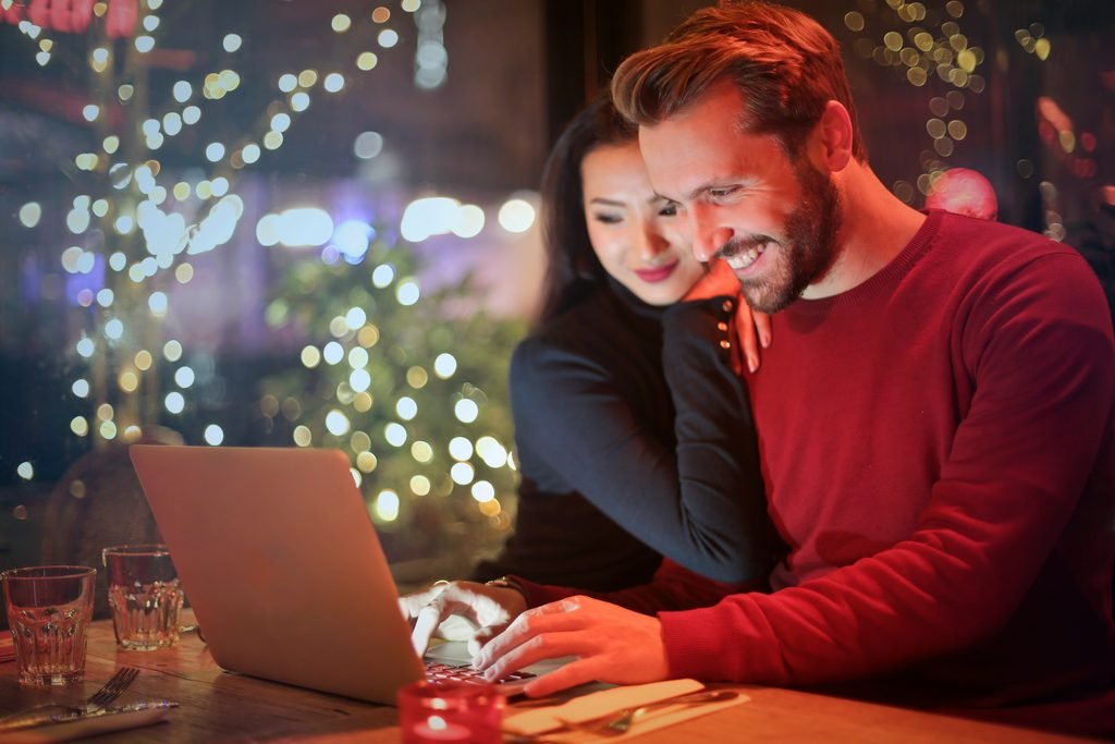 young couple celebrating investment gains together at home