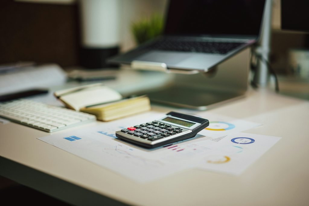 Spreadsheet and calculator showing income and expenses, representing calculating your real net