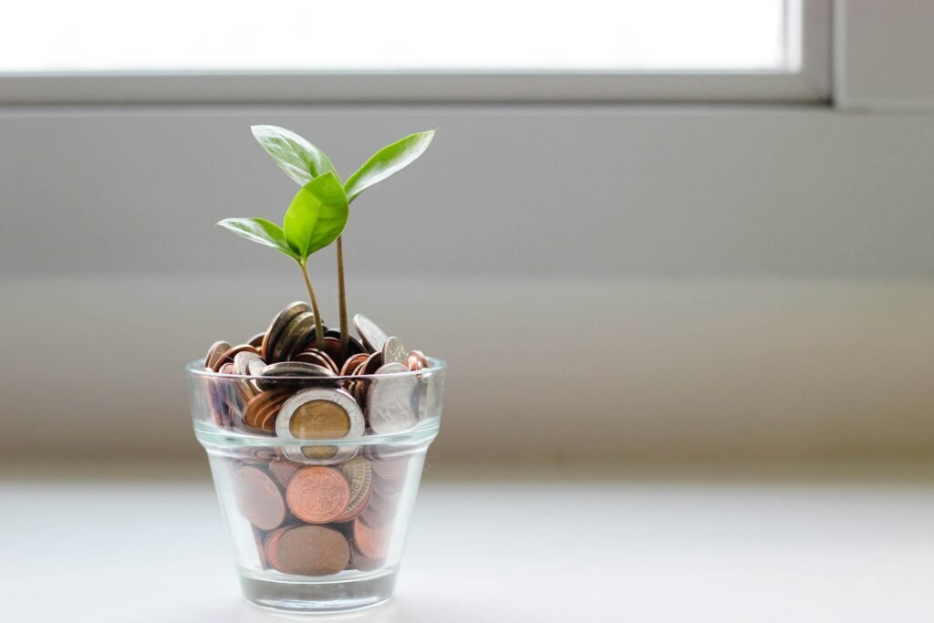 Coins in glass jar with plant sprouting, representing savings growing with income