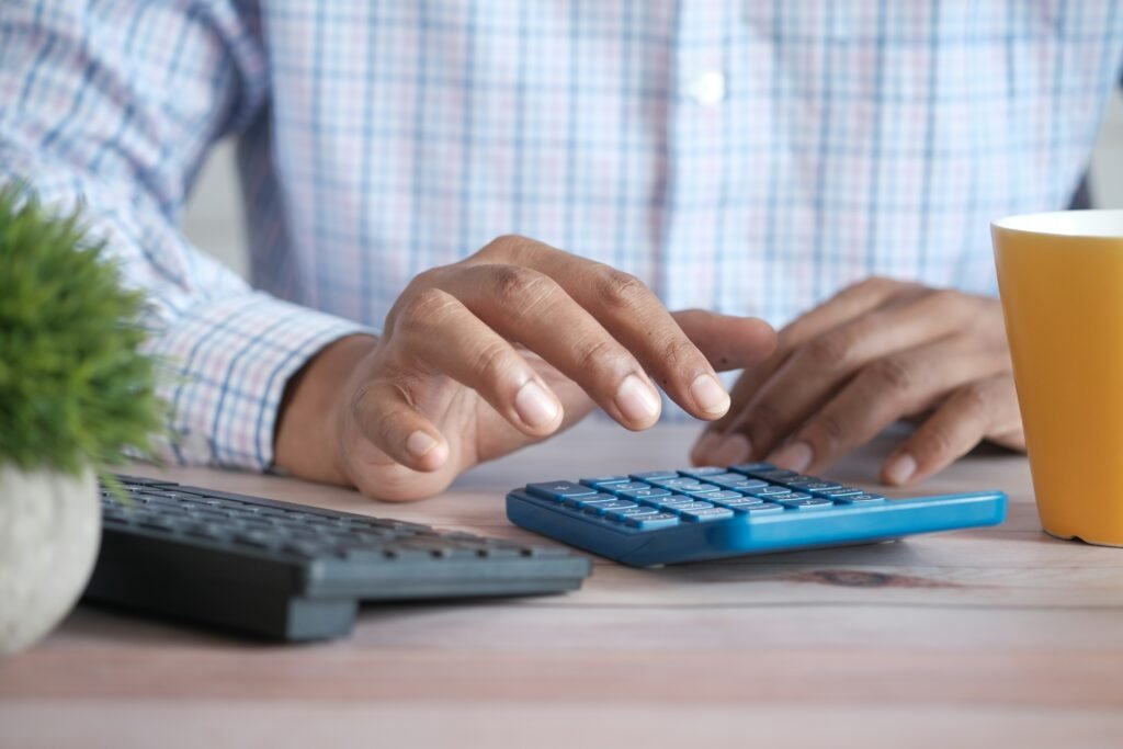 Calculator and paycheck, representing calculating the real math on a raise