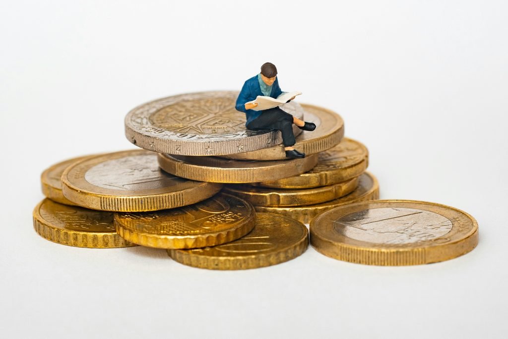 A person sitting on top of a coin.