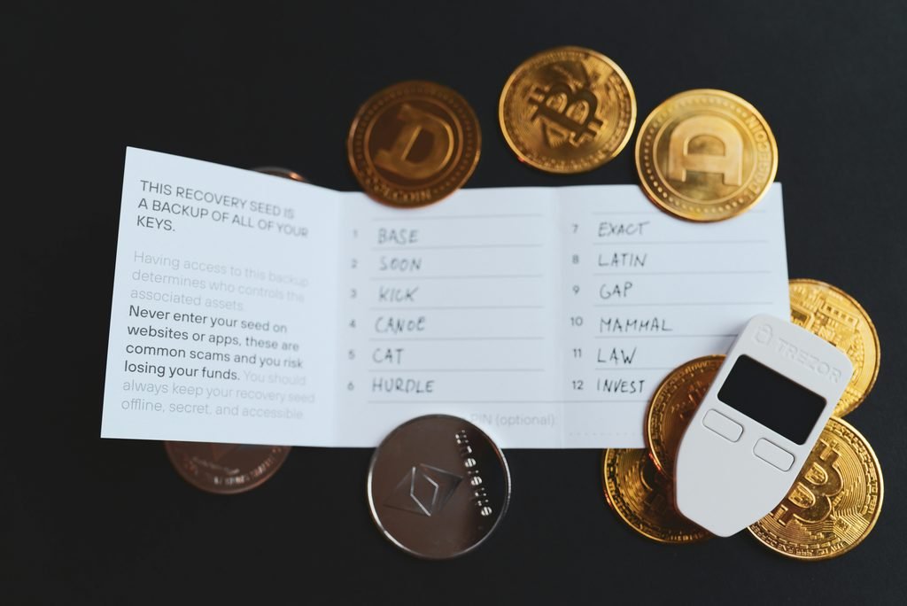 Crypto hardware wallet next to a handwritten paper seed phrase backup.